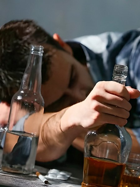 пьяный мужчина лежит за столом